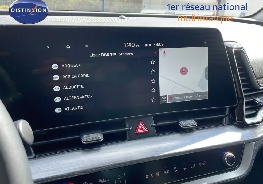 Écran tactile central du tableau de bord du Kia Sportage 2025, affichant la liste des radios et la navigation.