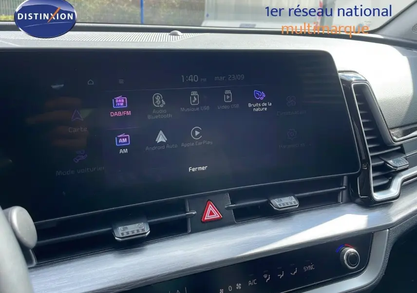 Écran tactile central du tableau de bord du Kia Sportage gris foncé 2025, affichant les options multimédia et climatisation.