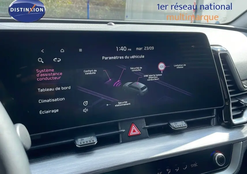 Vue intérieure centrée sur l'écran tactile du tableau de bord du KIA Sportage gris foncé 2025 avec affichage des aides à la conduite.