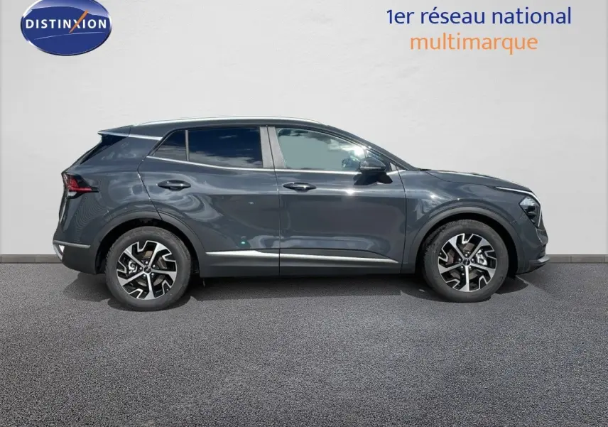 Profil côté gauche du SUV KIA SPORTAGE gris foncé métallisé avec jantes alliage bicolores sur fond neutre.