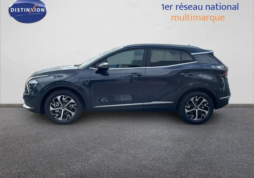 Profil côté gauche d'un Kia Sportage gris foncé métal 2025 avec jantes alliage bicolores et lignes modernes.