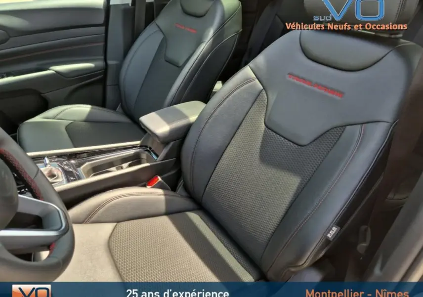 Intérieur du Jeep Compass 2022 gris foncé, vue sur sièges avant en cuir avec surpiqûres rouges Trailhawk.