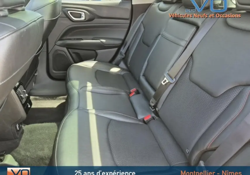 Vue intérieure des sièges arrière en cuir noir du Jeep Compass 2022, version hybride Trailhawk, avec ceintures de sécurité visibles.