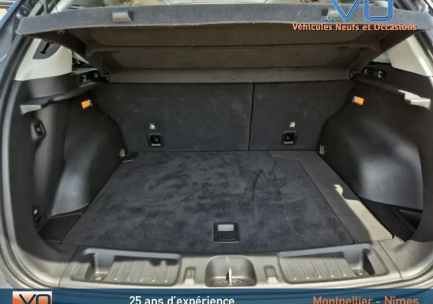 Coffre spacieux du Jeep Compass Trailhawk 2022 gris foncé, vu de l'arrière avec la tablette cache-bagages relevée.