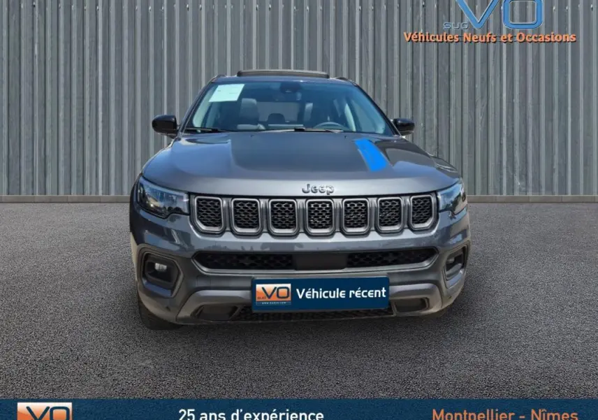 Vue frontale d'un Jeep Compass gris foncé 2022, version hybride Trailhawk avec calandre distinctive à sept fentes.