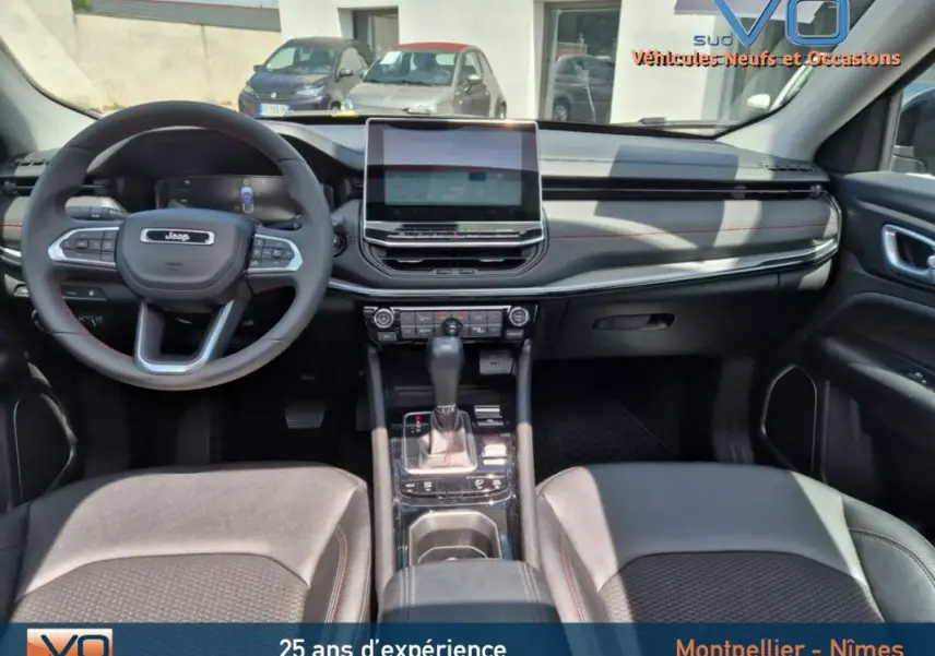 Intérieur du Jeep Compass 2022, vue frontale du tableau de bord avec écran tactile et volant multifonction.