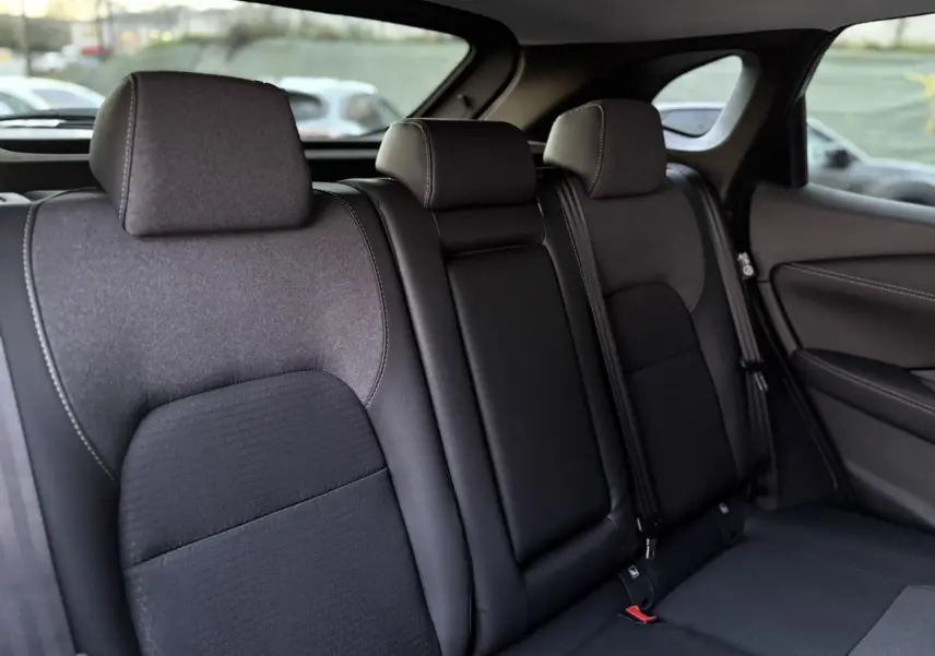 Vue intérieure des sièges arrière noirs du Nissan Qashqai III e-Power 2025, avec appuie-têtes et ceintures visibles.
