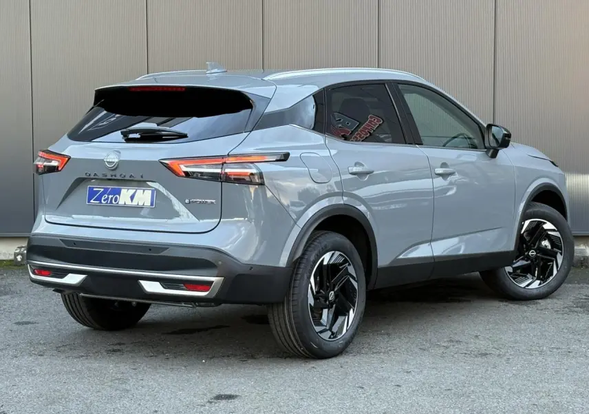 Vue 3/4 arrière droite d'un Nissan Qashqai gris Ceramic avec jantes alliage noires et vitres teintées.
