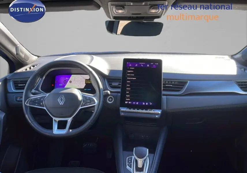 Gros plan sur la roue arrière droite d’un Renault Symbioz bleu iron metal avec jante noire et blanche au design géométrique.