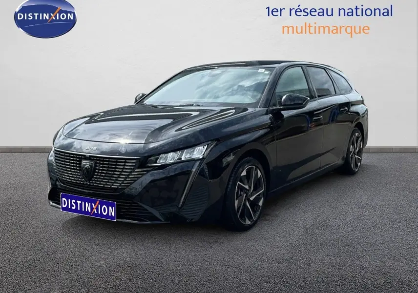 Peugeot 308 SW Hybrid noir métal en 3/4 avant droit, avec calandre distinctive et jantes alliage bicolores.