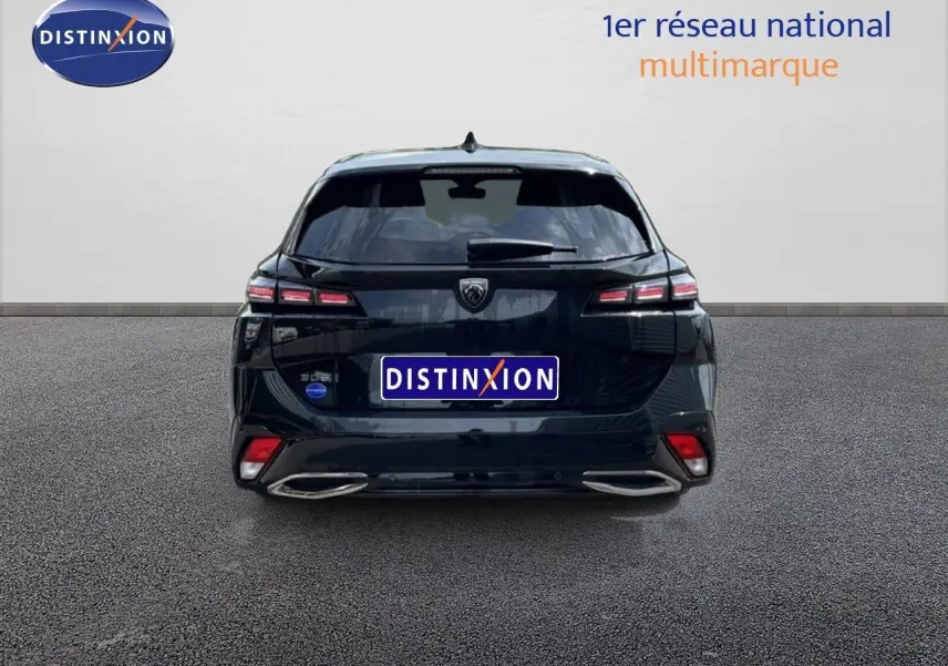 Vue arrière d'une Peugeot 308 SW Hybrid 145ch noire métal, avec feux LED et double sortie d'échappement intégrée.