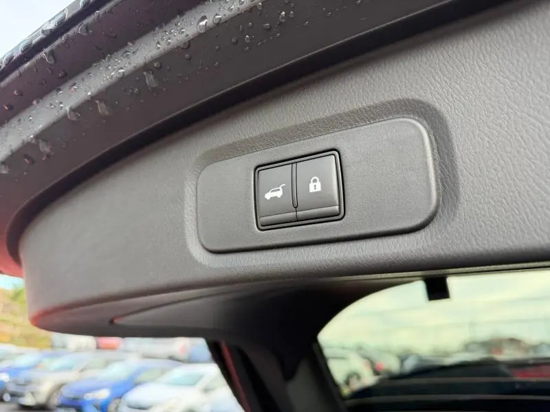 Boutons de commande de hayon et verrouillage sur le bord intérieur du coffre d'un Nissan Qashqai Hybrid e-POWER noir 2025.