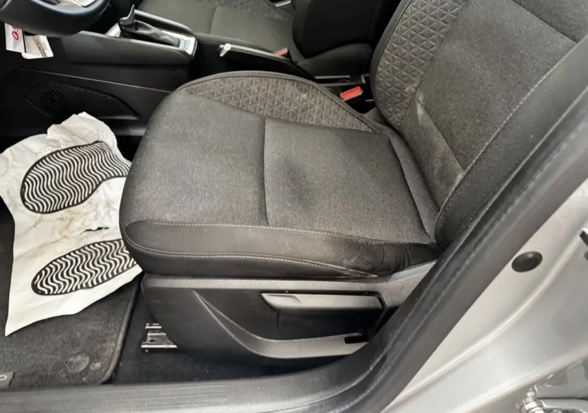 Vue rapprochée du siège avant droit en tissu noir de la Renault Clio Business E-TECH gris clair, porte ouverte.