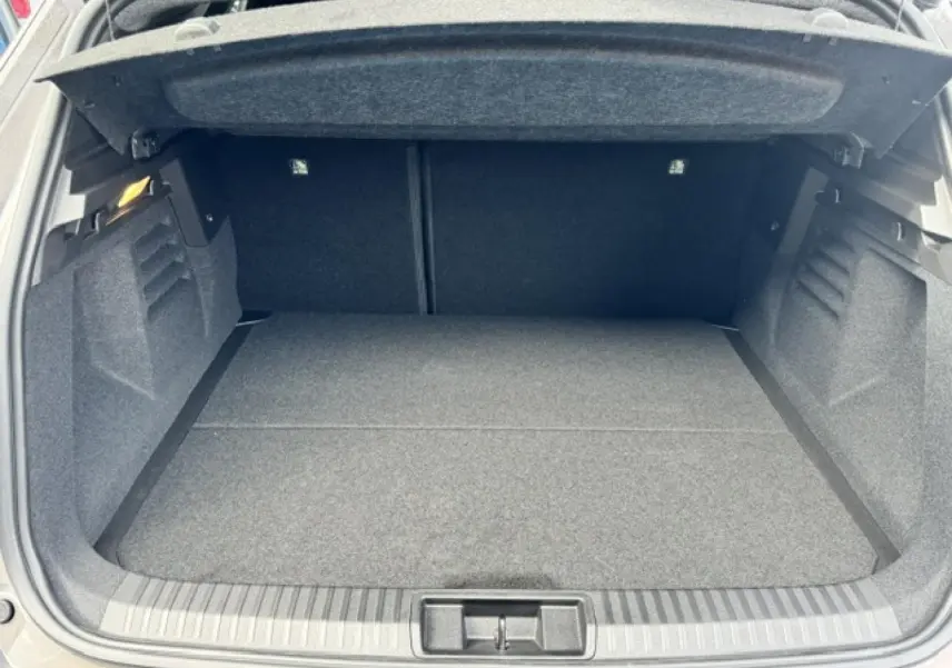 Coffre ouvert vu de face d'une Renault SYMBIOZ gris Cassiopée métallisé, espace de chargement vide et propre.