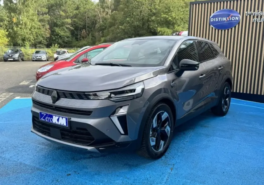 Renault Symbioz gris Cassiopée métallisé, vue 3/4 avant droit, avec jantes noires et détails modernes LED.