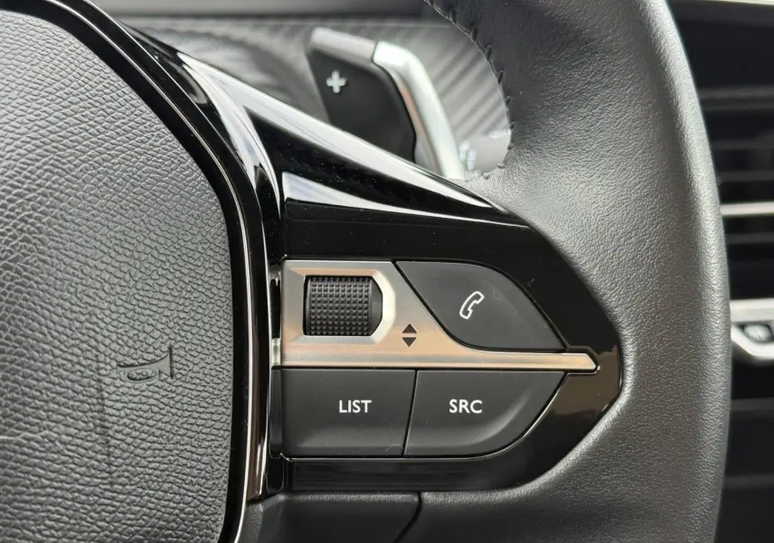 Gros plan sur les commandes audio et téléphone au volant noir du Peugeot 208 1.2 Hybrid 110ch Style 2025.