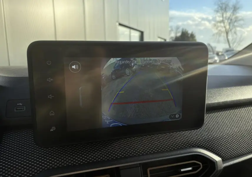 Écran tactile intérieur montrant la caméra de recul du Dacia Sandero Stepway blanc glacier, vue du tableau de bord.