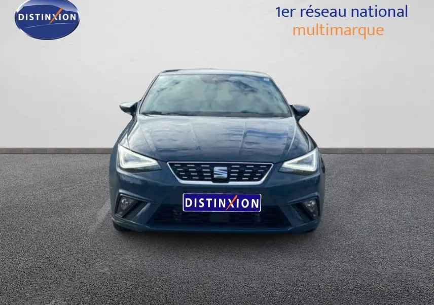 Vue frontale d'une SEAT Ibiza 2025 bleu fjord avec phares LED allumés sur un sol gris.