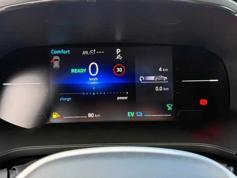 Affichage numérique du tableau de bord du Renault Captur 2025, montrant la vitesse à 0 km/h et l'autonomie hybride.