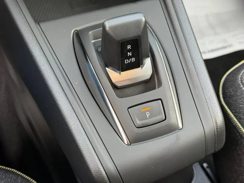 Gros plan sur la commande de boîte automatique noire du Renault Captur 2025, avec bouton de parking éclairé orange.