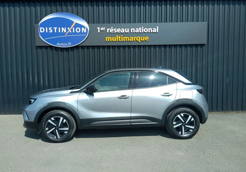 Vue latérale droite d'un Opel Mokka électrique gris 2025, avec jantes noires et détails noirs contrastants sur les passages de roues.