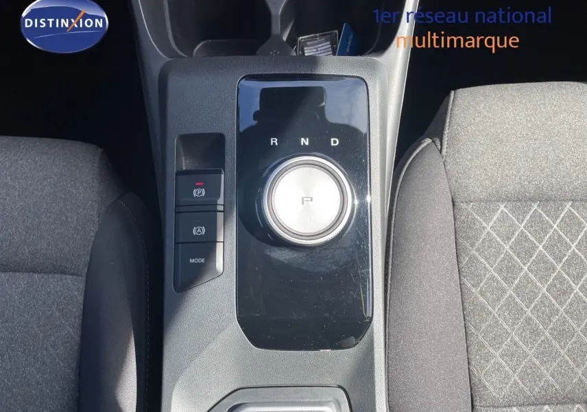 Vue plongeante sur la console centrale noire du MG3 2024 avec sélecteur rotatif de boîte auto et sièges tissu gris.