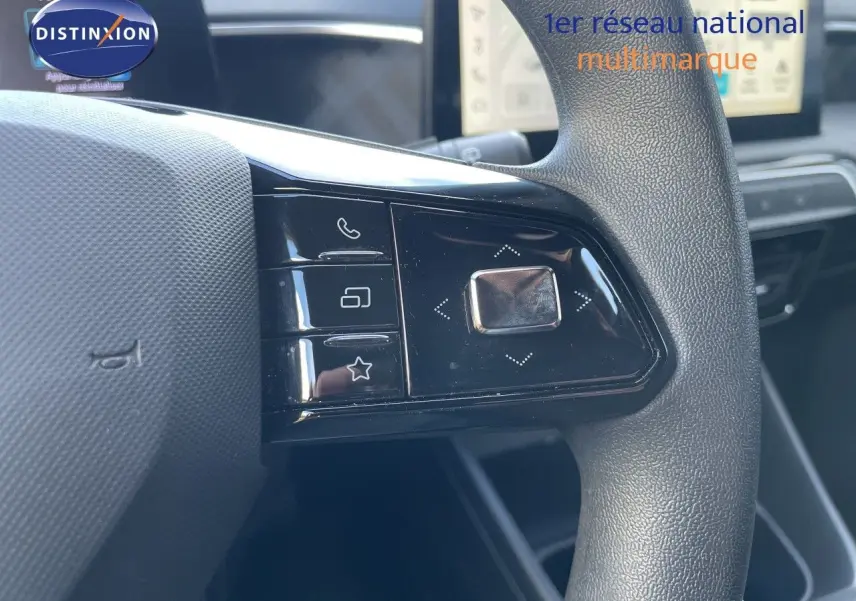 Gros plan sur les commandes gauche du volant du MG3 1.5L Hybrid+ 2024 avec finition noire et tableau de bord en arrière-plan.
