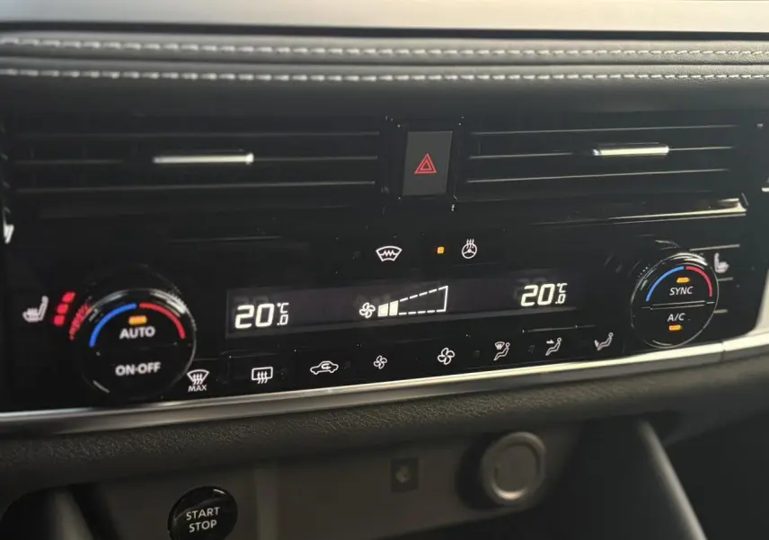 Gros plan sur la console centrale du Nissan Qashqai gris Ceramic, affichant la climatisation automatique bi-zone à 20°C.