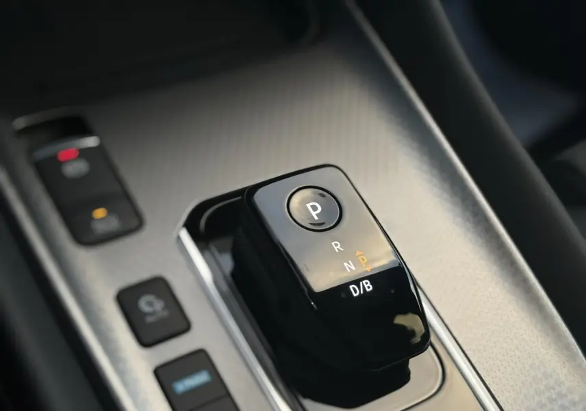 Gros plan sur le sélecteur de boîte automatique noir brillant du Nissan Qashqai III e-Power, intérieur gris texturé.