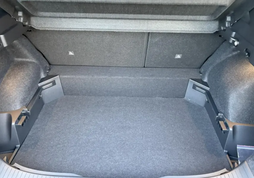 Vue intérieure du coffre spacieux et modulable du Nissan Qashqai III e-Power en gris Ceramic, avec revêtement sombre.