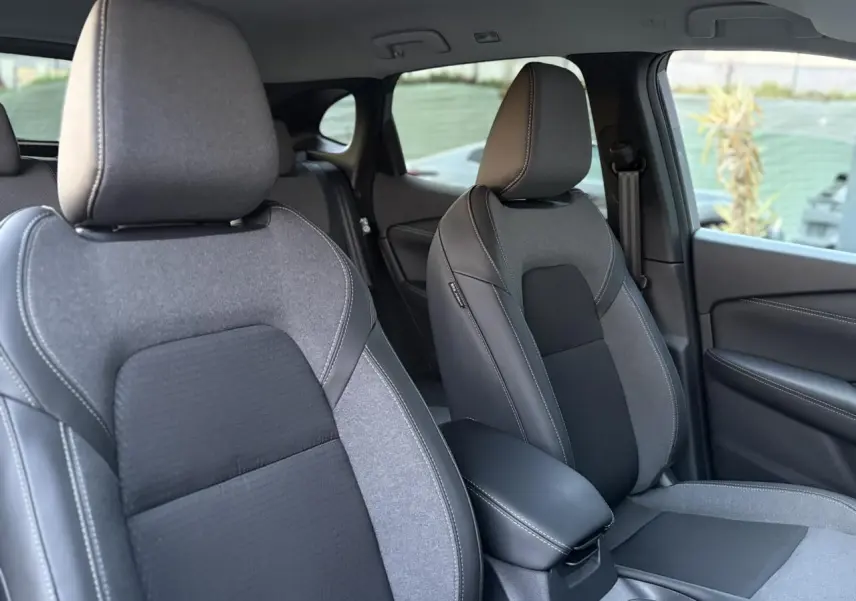 Vue intérieure sur les sièges avant gris et noirs du Nissan Qashqai III e-Power, avec accoudoir central et porte côté droit.