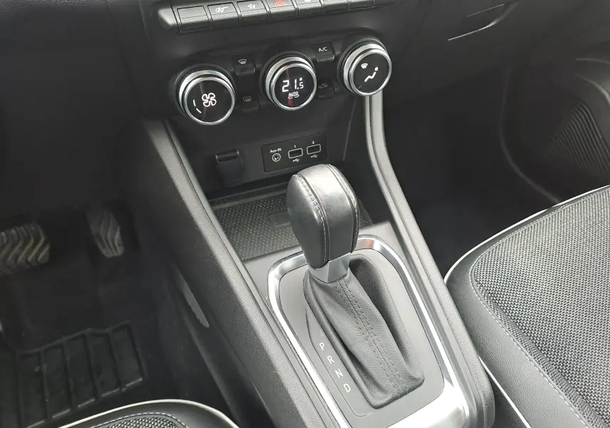 Gros plan sur la console centrale du Renault Captur bleu marine 2022, montrant le levier de boîte auto et les commandes de climatisation.