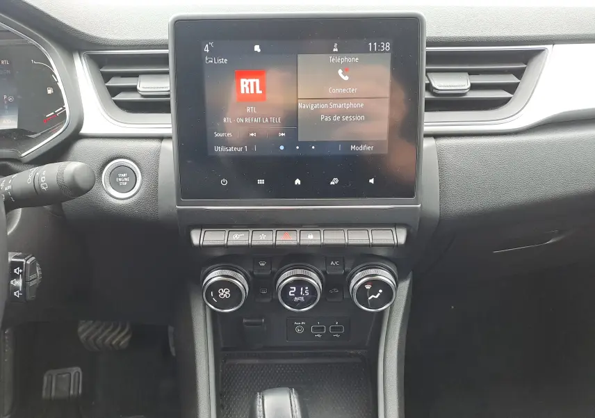 Vue intérieure centrée sur la console centrale du Renault Captur 2022, écran tactile et commandes de climatisation visibles.