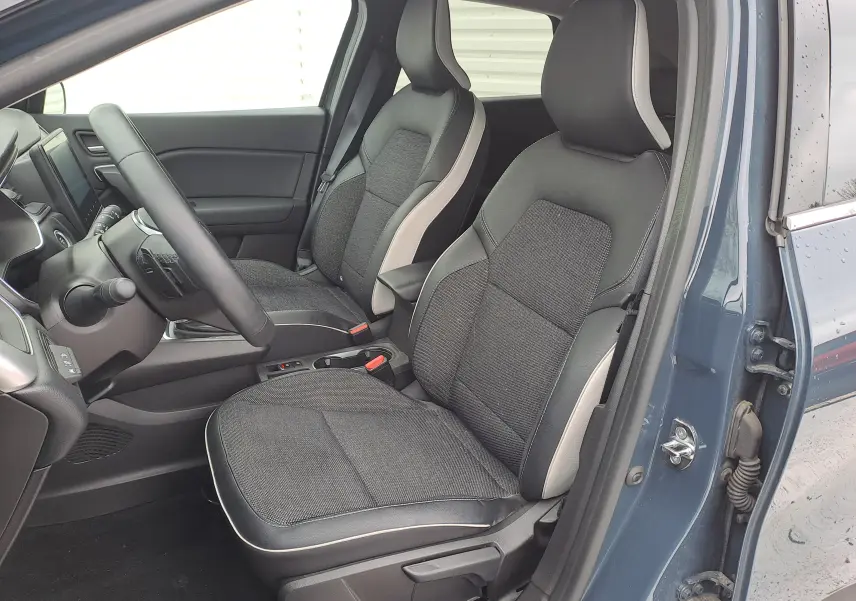 Vue intérieure côté conducteur du Renault Captur bleu marine 2022, sièges tissu noir avec surpiqûres claires.