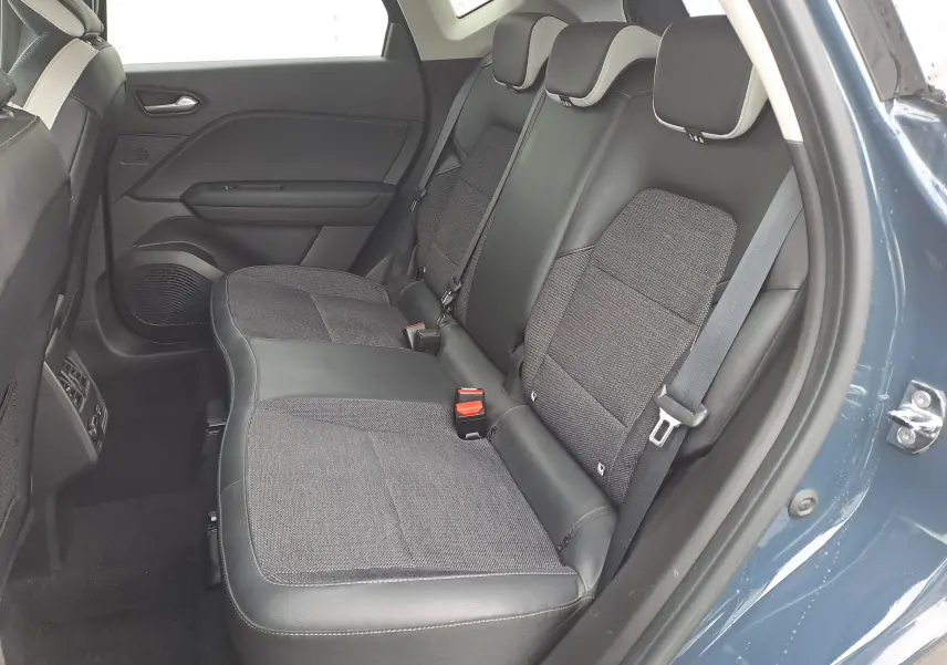 Vue intérieure côté droit des sièges arrière en tissu et cuir noir du Renault Captur bleu marine 2022, porte ouverte.