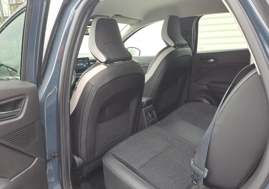 Vue intérieure arrière du Renault Captur bleu marine 2022, montrant les sièges arrière en tissu et cuir noir.