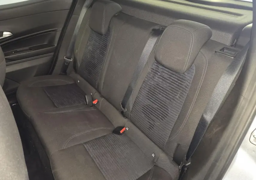 Vue intérieure de la banquette arrière noire de l'Alfa Romeo Junior 1.2 Ibrida 2025, avec ceintures de sécurité visibles.