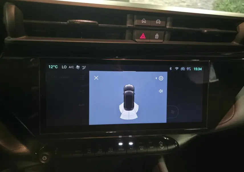 Écran tactile central affichant l’aide au stationnement de l’Alfa Romeo Junior 1.2 Ibrida gris, vue intérieure du tableau de bord.