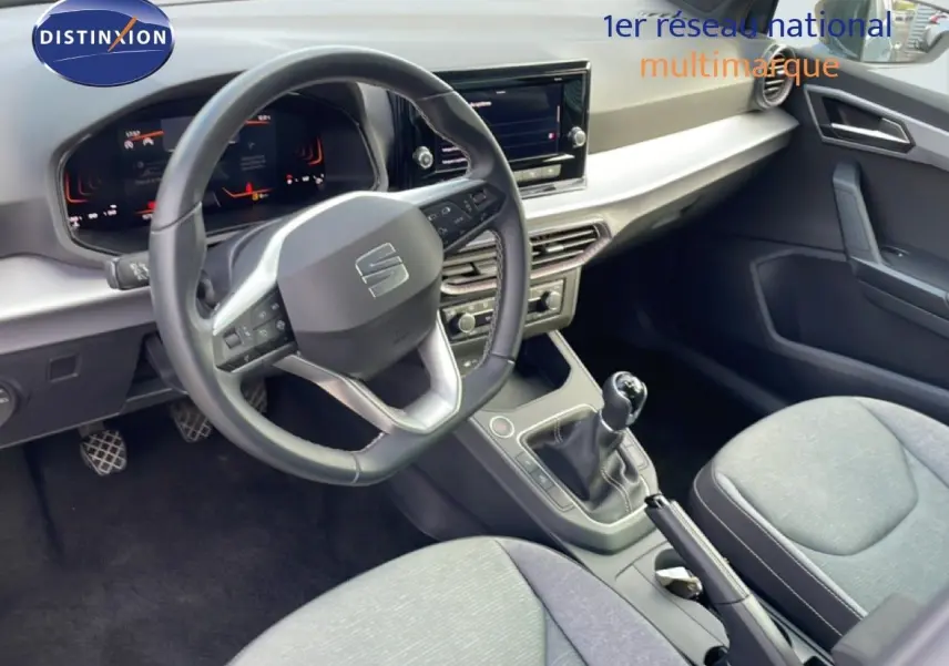 Vue intérieure du poste de conduite de la SEAT IBIZA 2025, volant cuir noir et levier de vitesse manuel visible.