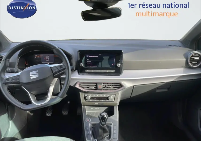 Vue intérieure du tableau de bord de la SEAT Ibiza 2025 bleu Fjord, avec volant multifonction et boîte manuelle.