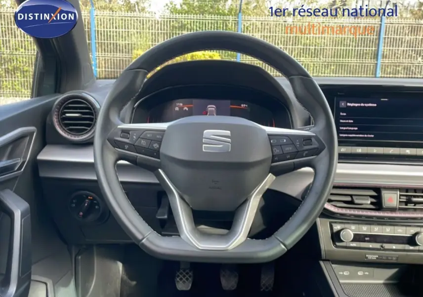 Vue intérieure centrée sur le volant multifonction noir de la SEAT Ibiza 2025 avec tableau de bord digital et écran tactile.