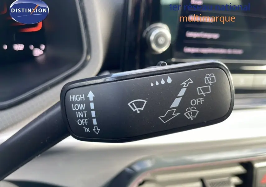 Gros plan sur la manette des essuie-glaces dans l’habitacle d’une SEAT Ibiza bleu Fjord 2025, avec tableau de bord flou.
