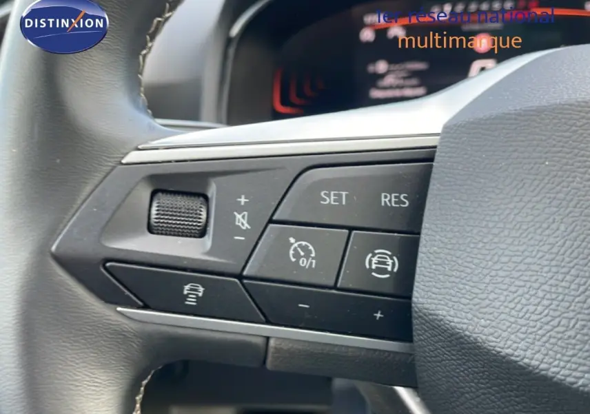 Gros plan sur les commandes de régulateur de vitesse au volant d’une SEAT Ibiza bleu Fjord 2025.