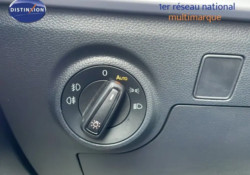 Gros plan sur le bouton de commande des phares dans l’habitacle d’une SEAT Ibiza bleu Fjord 2025.