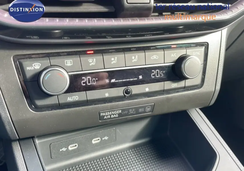 Détail de la console centrale avec la climatisation automatique affichant 20°C, boutons et ports USB visibles, intérieur noir.