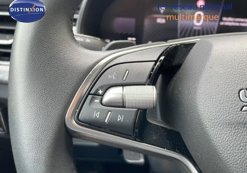 Gros plan sur les commandes gauche du volant d’une Skoda Scala 2025, finition noire avec molette texturée.