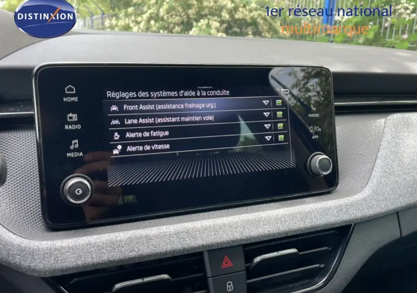 Écran tactile central de la Skoda Scala 2025 affichant les réglages des aides à la conduite dans un intérieur gris noir.