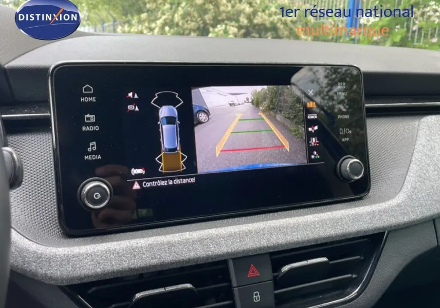 Vue rapprochée de l'écran central de la Skoda Scala bleu racing metal affichant la caméra de recul avec guidage.