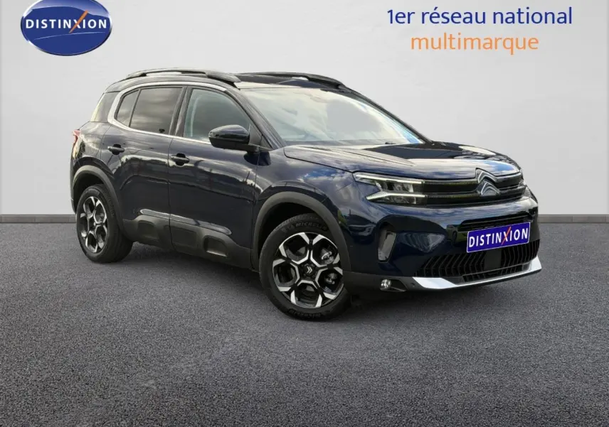 Citroën C5 Aircross Bleu Eclipse en 3/4 avant droit, avec jantes alliage et barres de toit visibles.