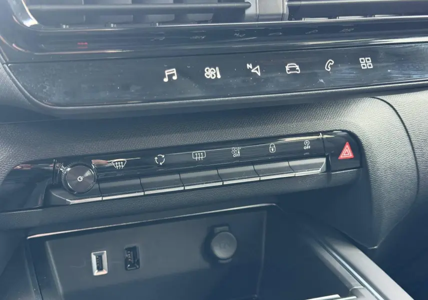 Détail de la console centrale noire du Citroën C5 Aircross 2025 avec commandes tactiles et prises USB et 12V visibles.